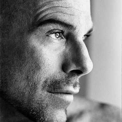 le visage d'un homme en noir et blanc qui regarde au loin