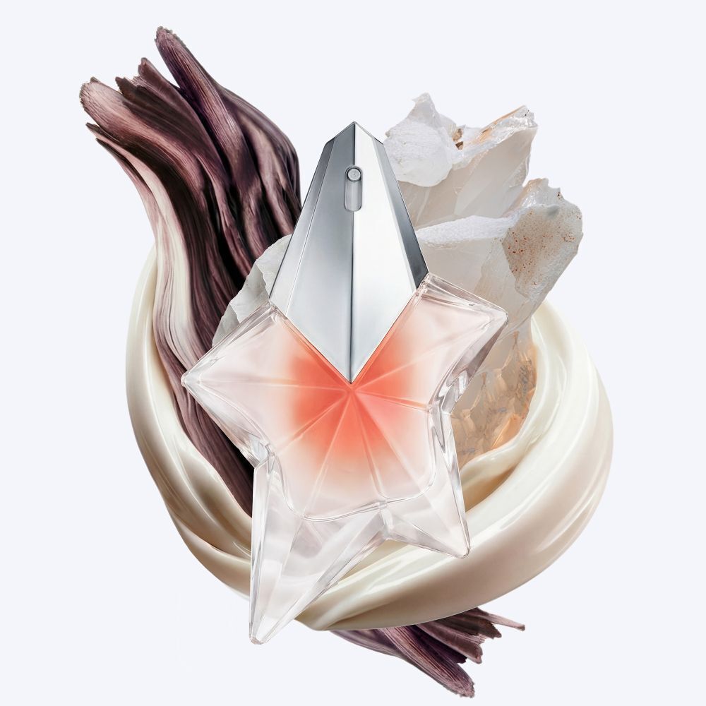 La bouteille Angel Blush etoile entouree de tourbillons cremeux de lait d’amande, de bois de santal texture et de muscs eclatants, illustrant les notes olfactives cles du parfum.