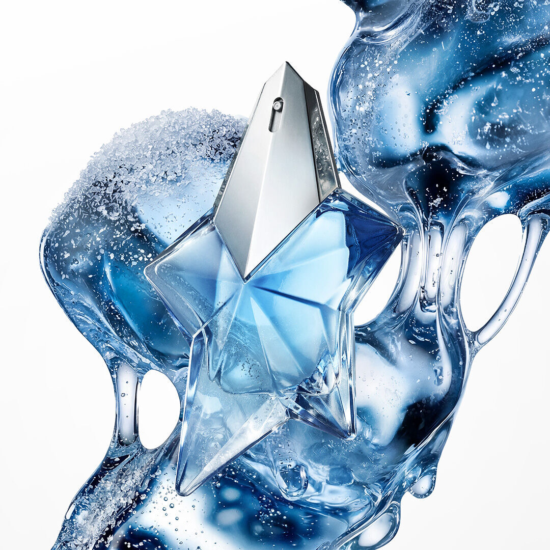 un flacon de parfum bleu en forme d'etoile avec de la matiere liquide bleu en arriere