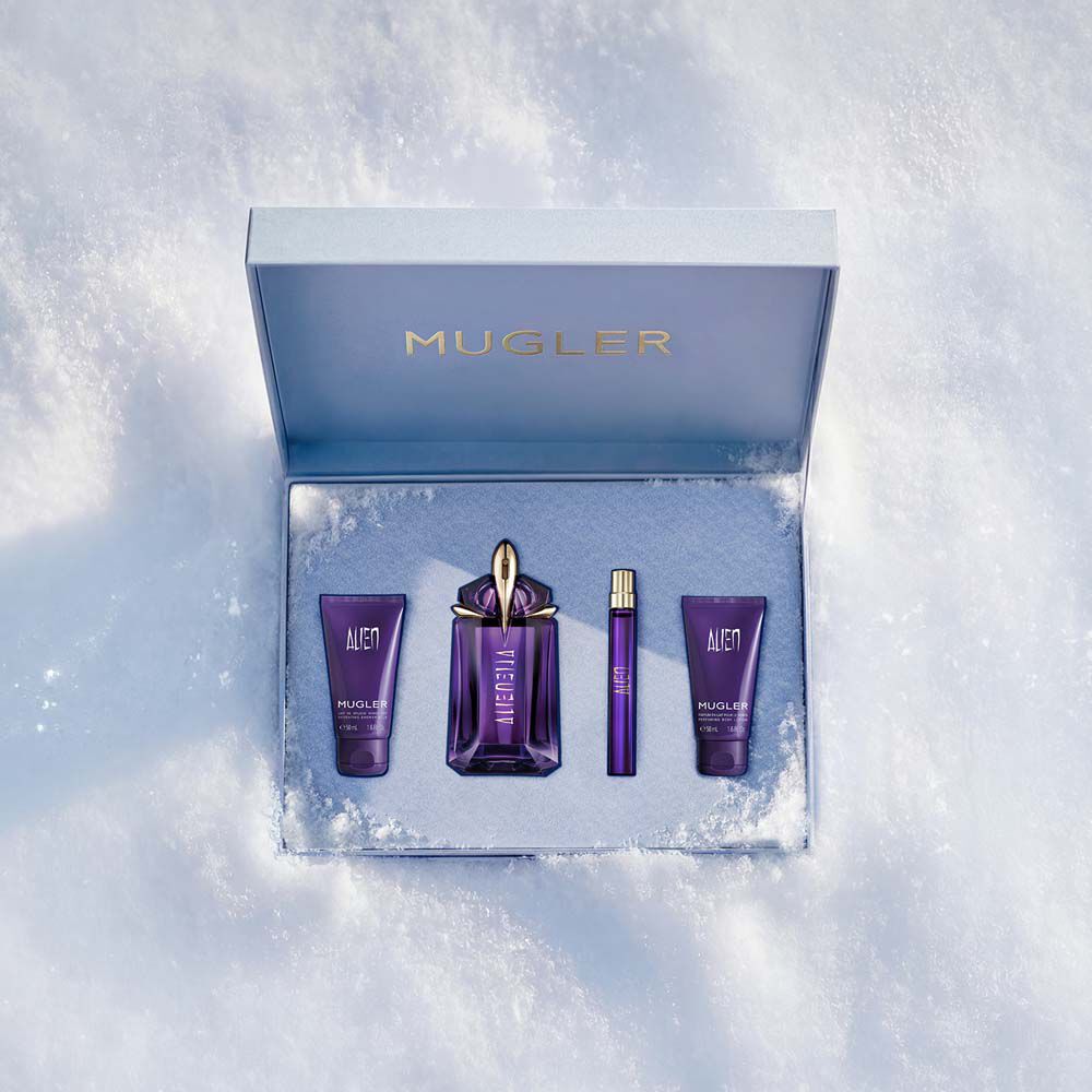 Un ensemble cadeau Mugler ouvert, texture et bleu glace brillant, reposant sur la neige, revelant un coffret cadeau de luxe de 60 ml alien eau de parfum