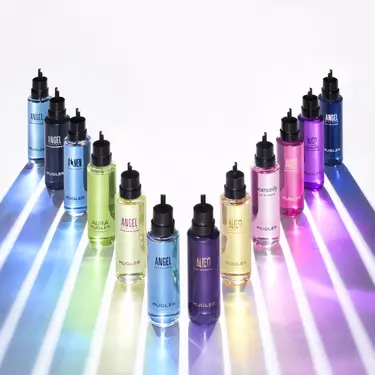 Une rangee de bouteilles de liquide de differentes couleurs formant un arc-en-ciel vibrant.