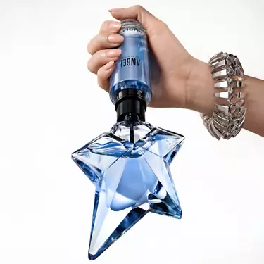 un flacon de parfum bleu angel avec une main qui tient un flacon recharge