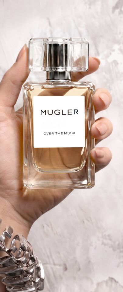 Une main feminine tenant une flacon de Mugler Over the Musk