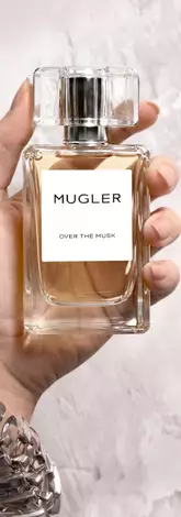 Une main feminine tenant une flacon de Mugler Over the Musk