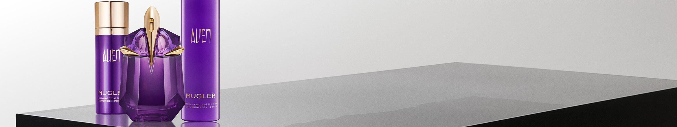 une brume, un parfum et un lait pour le corps violet mugler sur un fond blanc