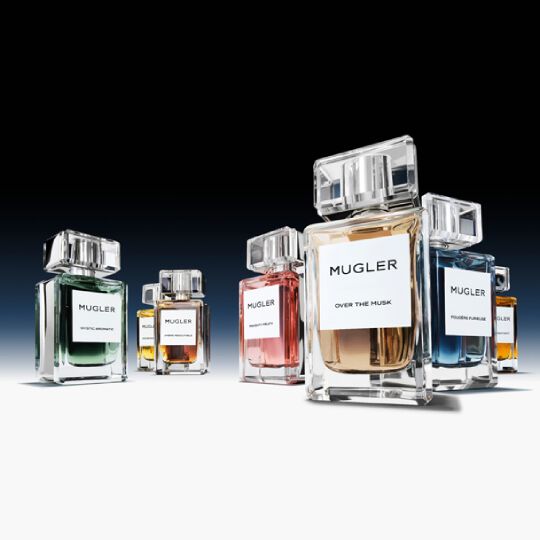 Flacons de parfums sur fond noir, evoquant elegance et luxe.