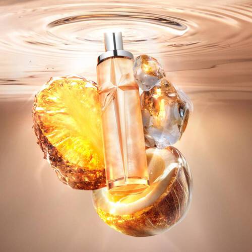 Un flacon de parfum orange en forme d'etoile flottant dans l'eau, avec des ananas et des noix de coco