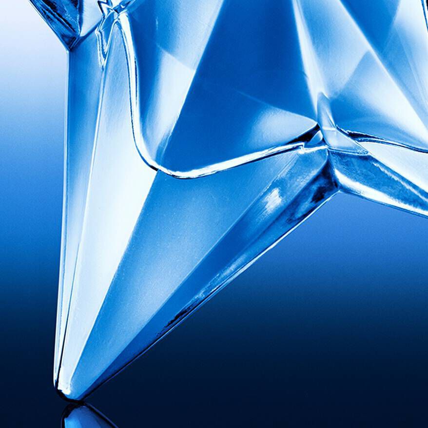 A close-up of a clear glass star-shaped object reflecting shades of blue against a dark background.