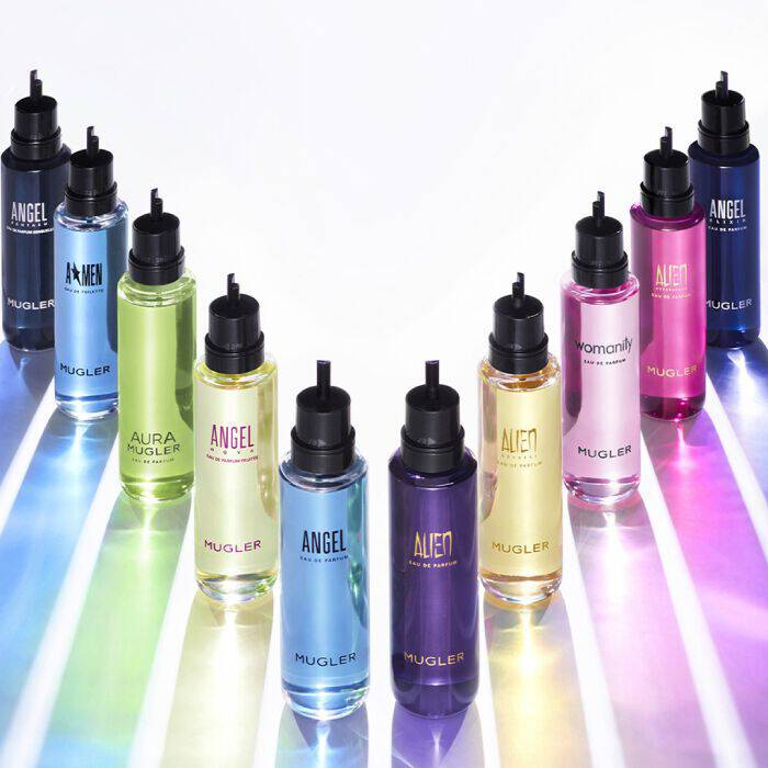Une gamme complete de flacons de recharge pour parfums Mugler, disponibles en plusieurs couleurs, presentes avec des rayons de lumiere colores sur fond blanc