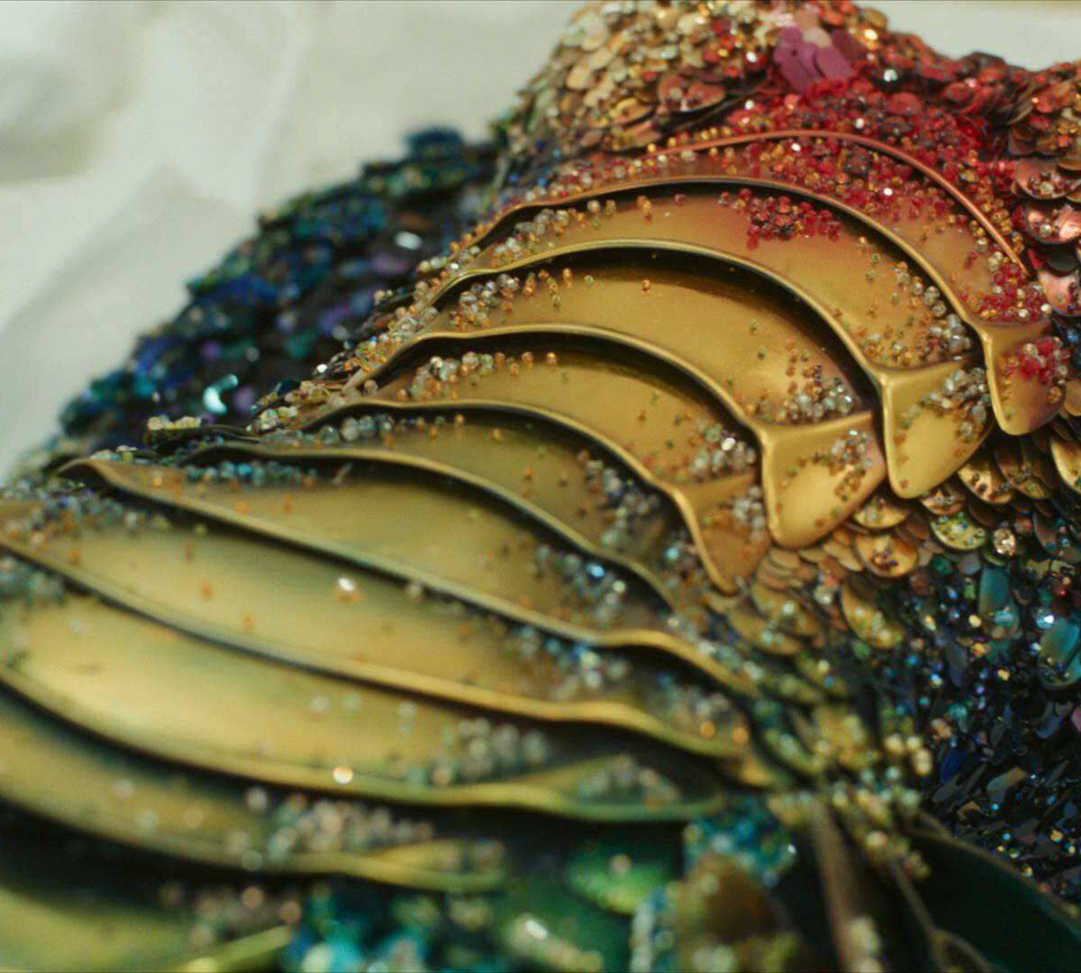 une armure doree avec des paillettes de couleurs poses dessus