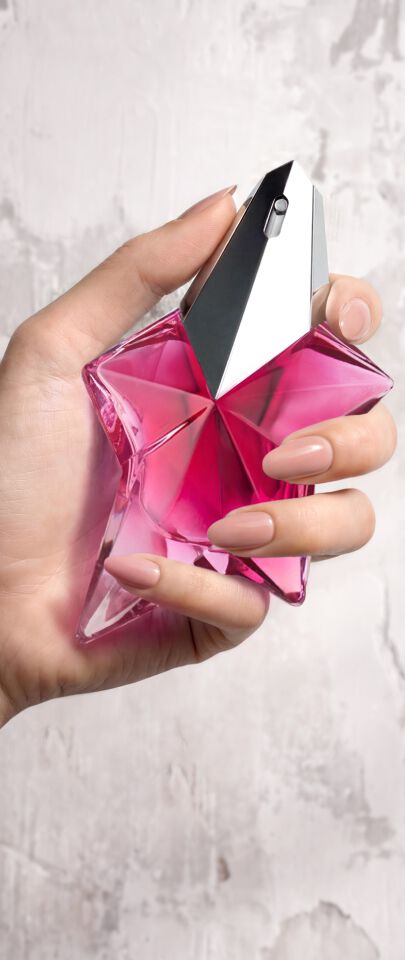 Une main feminine tenant une flacon de Mugler Angel Nova.
