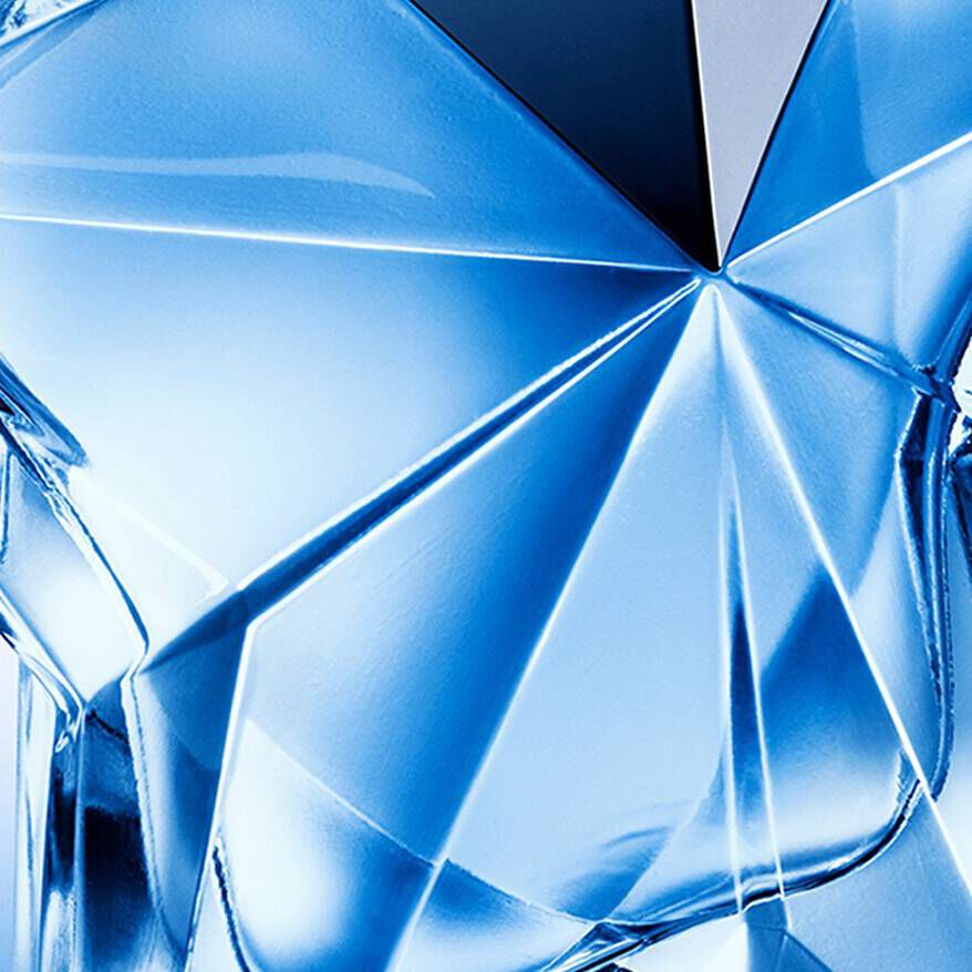 Two elegantly styled hands reach toward a blue crystal-shaped object. One hand, adorned with dark jewelry and polished nails, holds the object, while the other hand, featuring long, pointed nails, is poised to touch it. The background is a gradient of light to dark, creating a dramatic effect.
