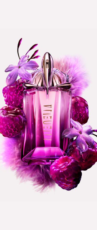 flacon de parfum rose alien entoure de framboises sur fond blanc