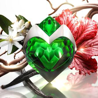 Flacon de parfum en forme de coeur vert, entoure de fleurs blanches et rouges, avec des branches et des gouttes d'eau.