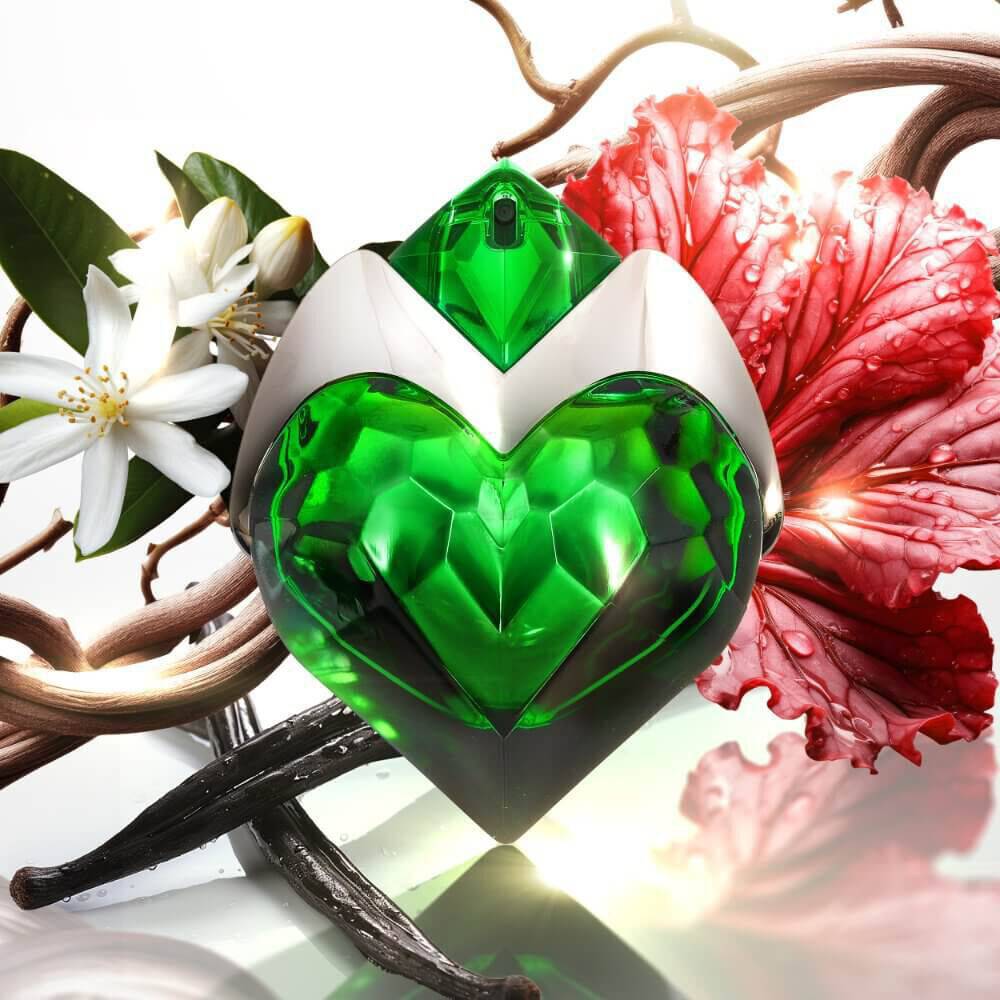 Flacon de parfum en forme de coeur vert, entoure de fleurs blanches et roses, avec des branches et des gouttes d'eau.