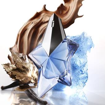 Une bouteille de parfum en forme d'etoile, a facettes transparentes et argentees, entouree de chocolat, de glace et de feuilles.