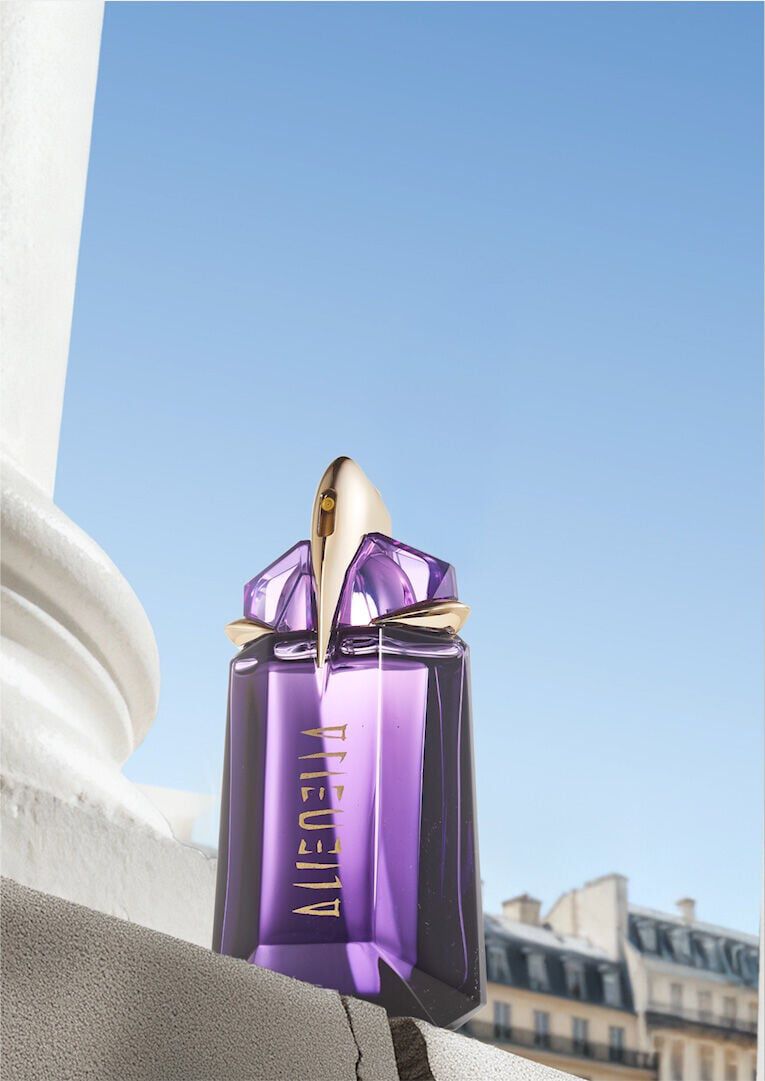 Mugler Mother's Day 2026 campaign banner featuring the iconic Alien Eau de Parfum perfume bottle in a celestial floral and Parisian landscape, celebrating extraordinary mothers.