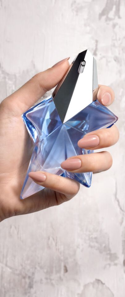 Une main feminine tenant une flacon de Mugler Angel