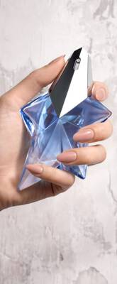 Une main feminine tenant une flacon de Mugler Angel