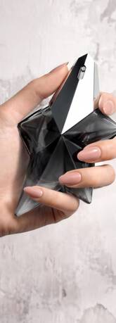 Une main feminine tenant une flacon de Mugler Angel Fantasm