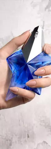 Une main feminine tenant une flacon de Mugler Angel Stellar