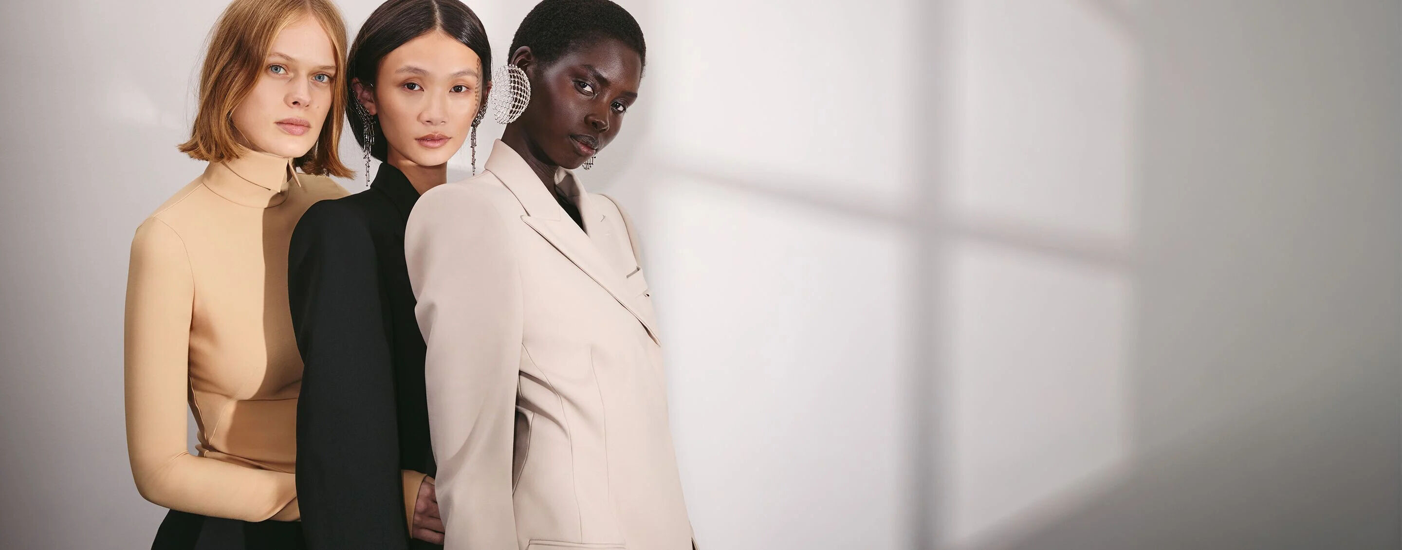 Mugler Circle (banniere de fidelite) : trois mannequins se tenant cote a cote, vetus d'elegants vetements sur mesure dans des tons creme, beige et rose, a cote d'informations invitant les utilisateurs a rejoindre le programme de fidelite Mugler Circle.