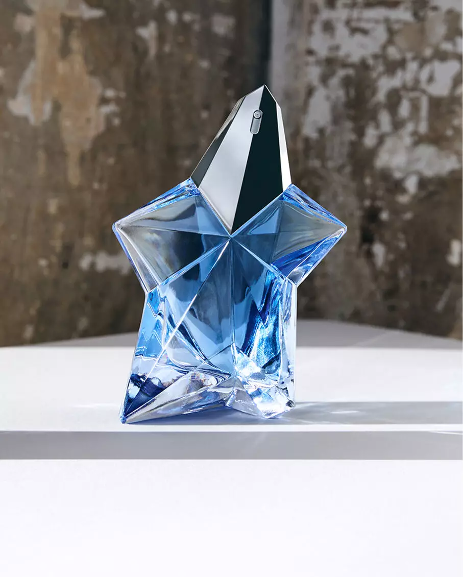 Flacon « Blue Star » de l'eau de parfum Mugler Angel pose sur une surface dans un studio.