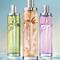 Trois flacons des nouveaux eaux de toilette Starlicious, de couleur verte, orange et rose, flottant sur l'eau, sur fond bleu