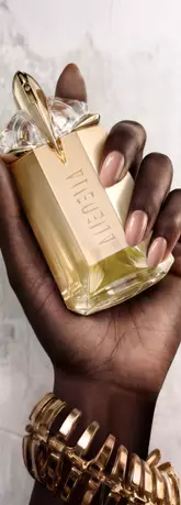 Une main feminine tenant une flacon de Mugler Alien Goddess.