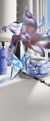 un flacon de parfum bleu un pot de creme bleu et un flacon pompe angel sur un sol carrele avec une fleur bleu a cote