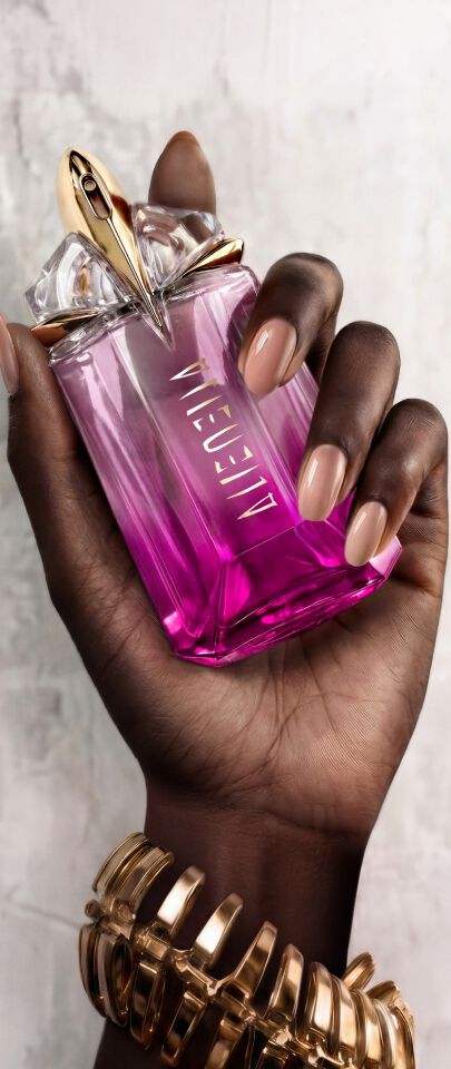 Une main feminine tenant une flacon de Mugler Alien Pulp