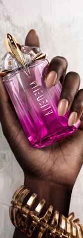 Une main feminine tenant une flacon de Mugler Alien Pulp
