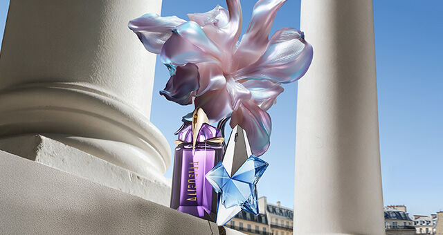 Mugler Mother's Day 2026 campaign banner featuring the iconic Angel and Alien perfume bottles in a celestial floral and Parisian landscape, celebrating extraordinary mothers.