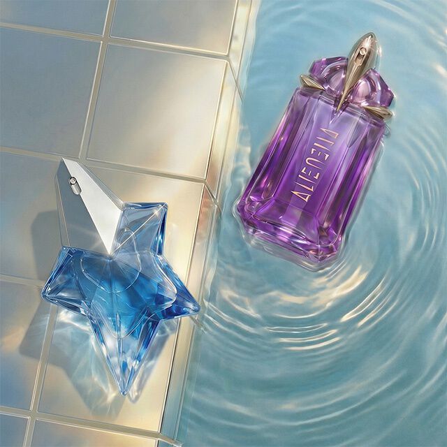 un flacon de parfum en forme d'etoile bleu et un autre violet poses dans un fond piscine.