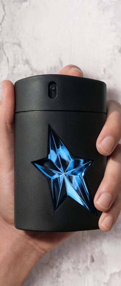 une main d'homme tient un flacon de Mugler A*Men.