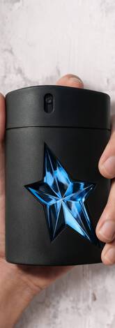 une main d'homme tient un flacon de Mugler A*Men.