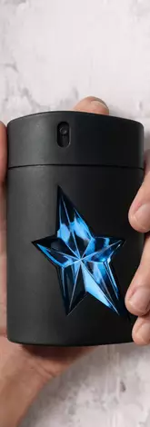 une main d'homme tient un flacon de Mugler A*Men.