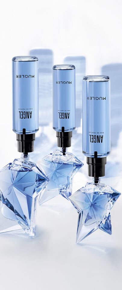 Trois flacons cylindriques bleus de recharge d eau de parfum, munis d'embouts noirs, sont inseres dans des flacons d eau de parfum transparents en forme d etoile. 