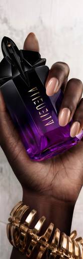 Une main feminine tenant une flacon de Mugler Alien Extraintense.