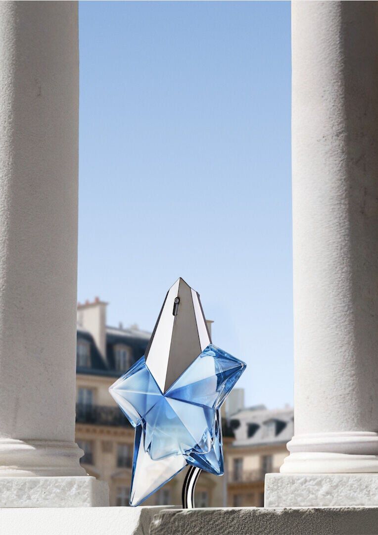 Mugler Mother's Day 2026 campaign banner featuring the iconic Angel Eau de Parfum perfume bottle in a celestial floral and Parisian landscape, celebrating extraordinary mothers.