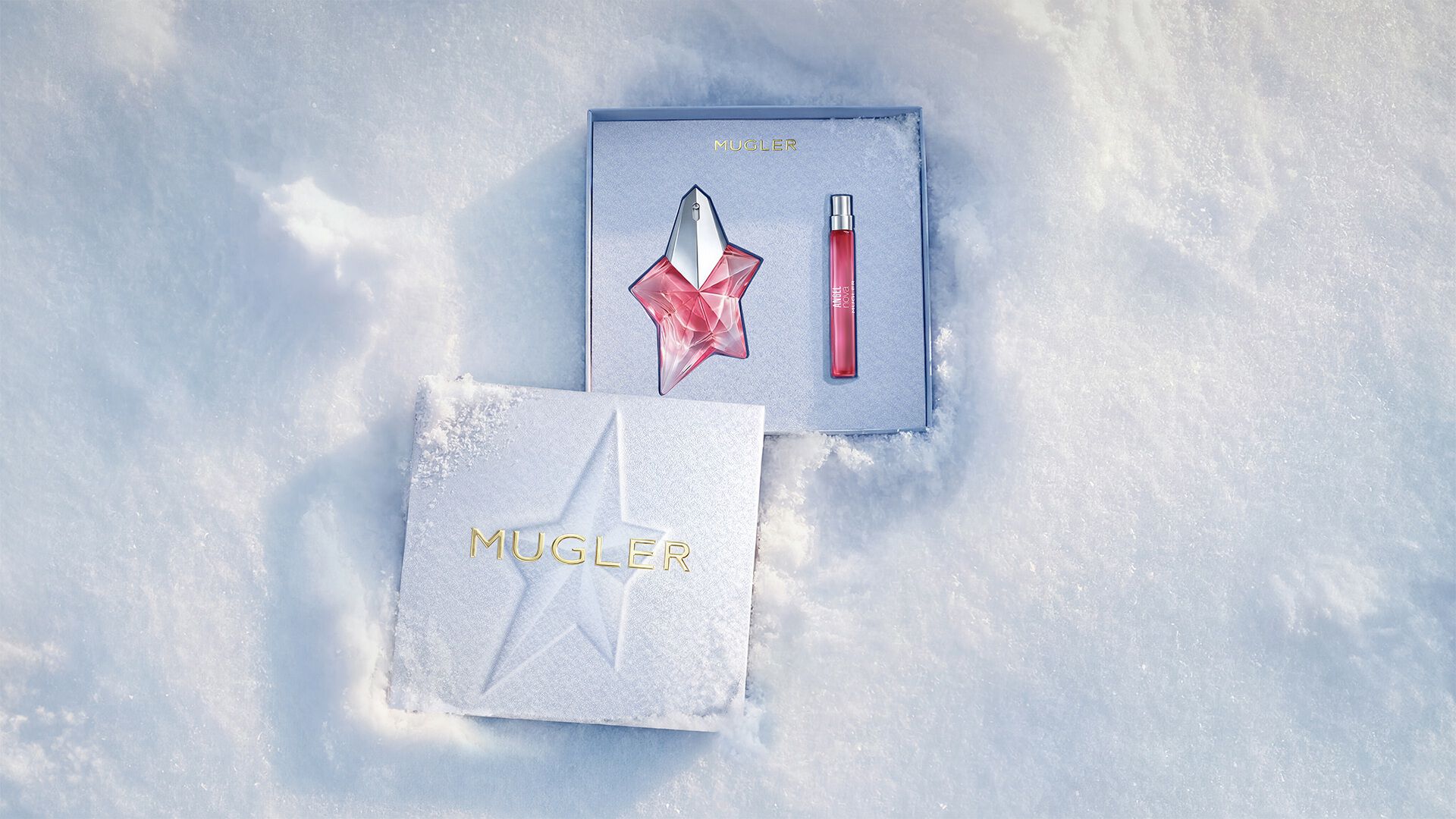 Un coffret cadeau Mugler bleu glacier, ouvert, texturé et scintillant, posé sur de la neige, dévoilant un coffret cadeau Angel Nova Eau de Parfum de 50 ml