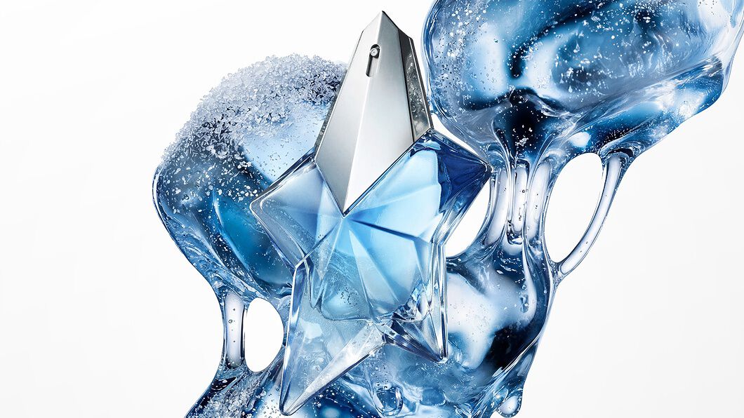 Flacon de parfum Angel de Mugler, sur fond abstrait bleu glacé et fluide