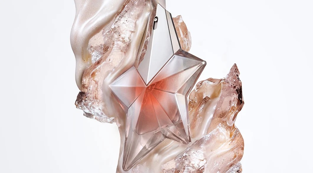 un parfum rose en forme d'étoile sur un fond rose pâle.