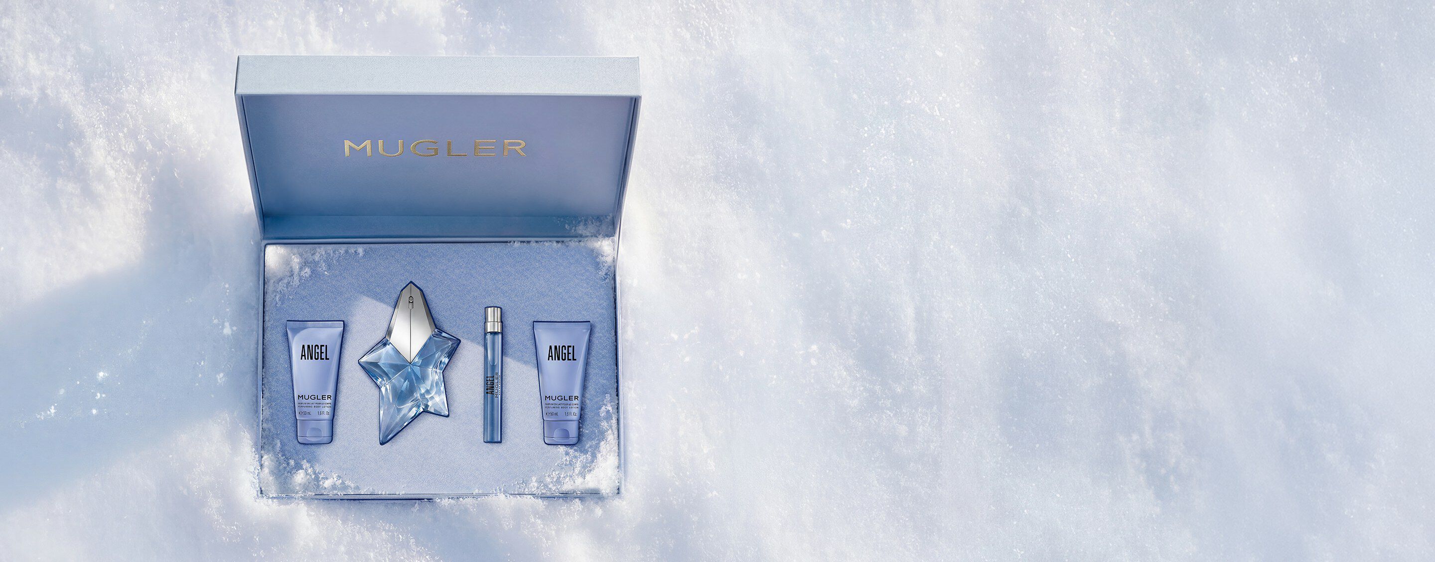Un coffret cadeau Mugler bleu glacier, ouvert, texturé et scintillant, posé sur de la neige, dévoilant un coffret cadeau de luxe contenant l eau de parfum Angel de 50 ml