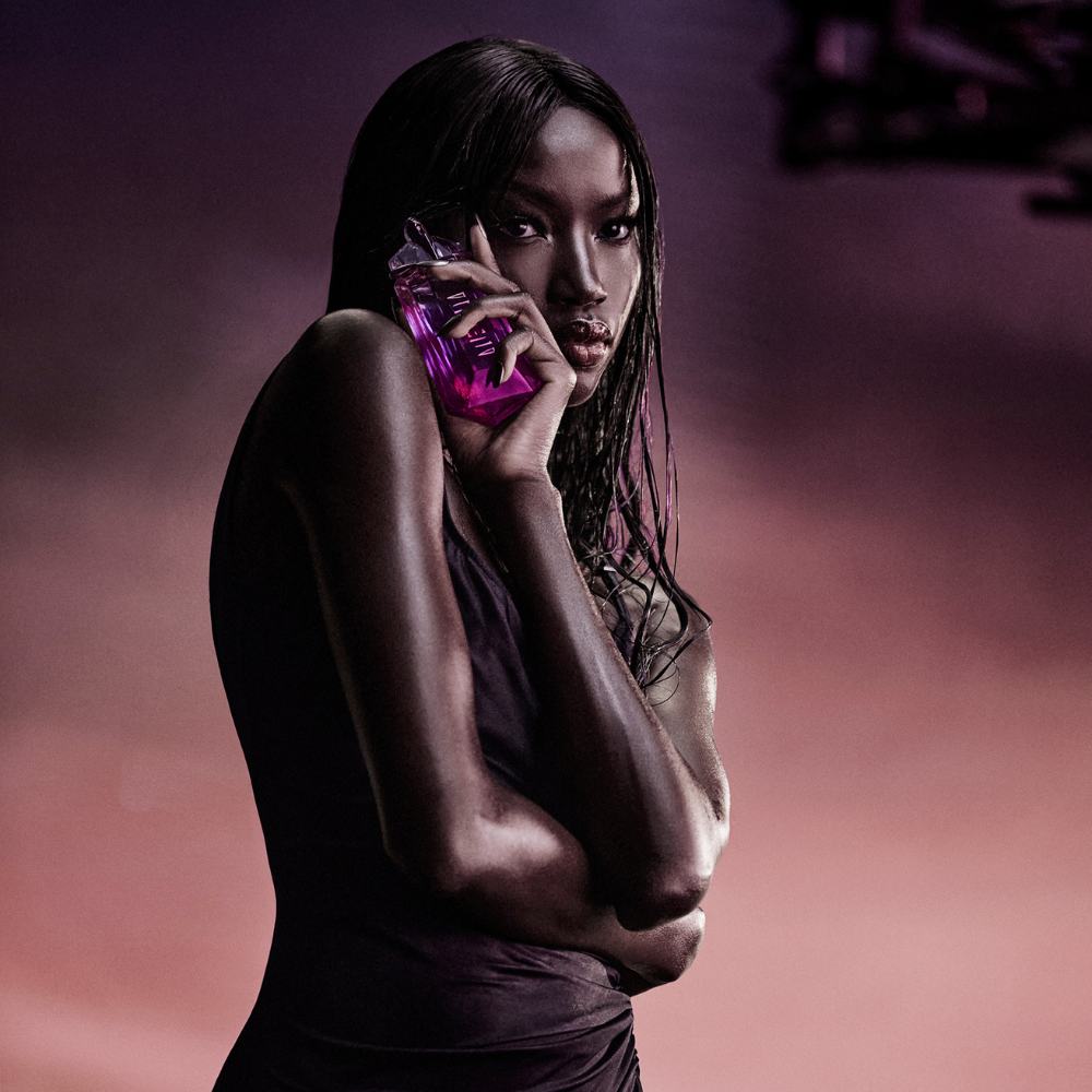 Une femme noire tenant le flacon alien pulp au dessus de son visage