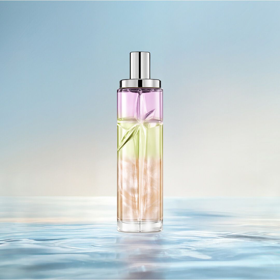 trois flacons de parfums vert, orange et rose sur un fond bleu