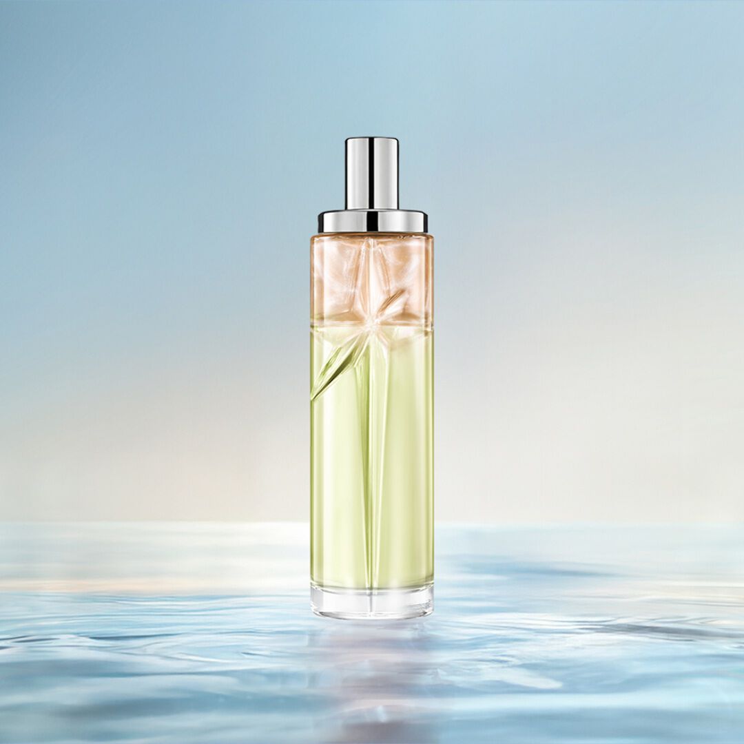 un flacon de parfum vert, orange et rose sur un fond bleu