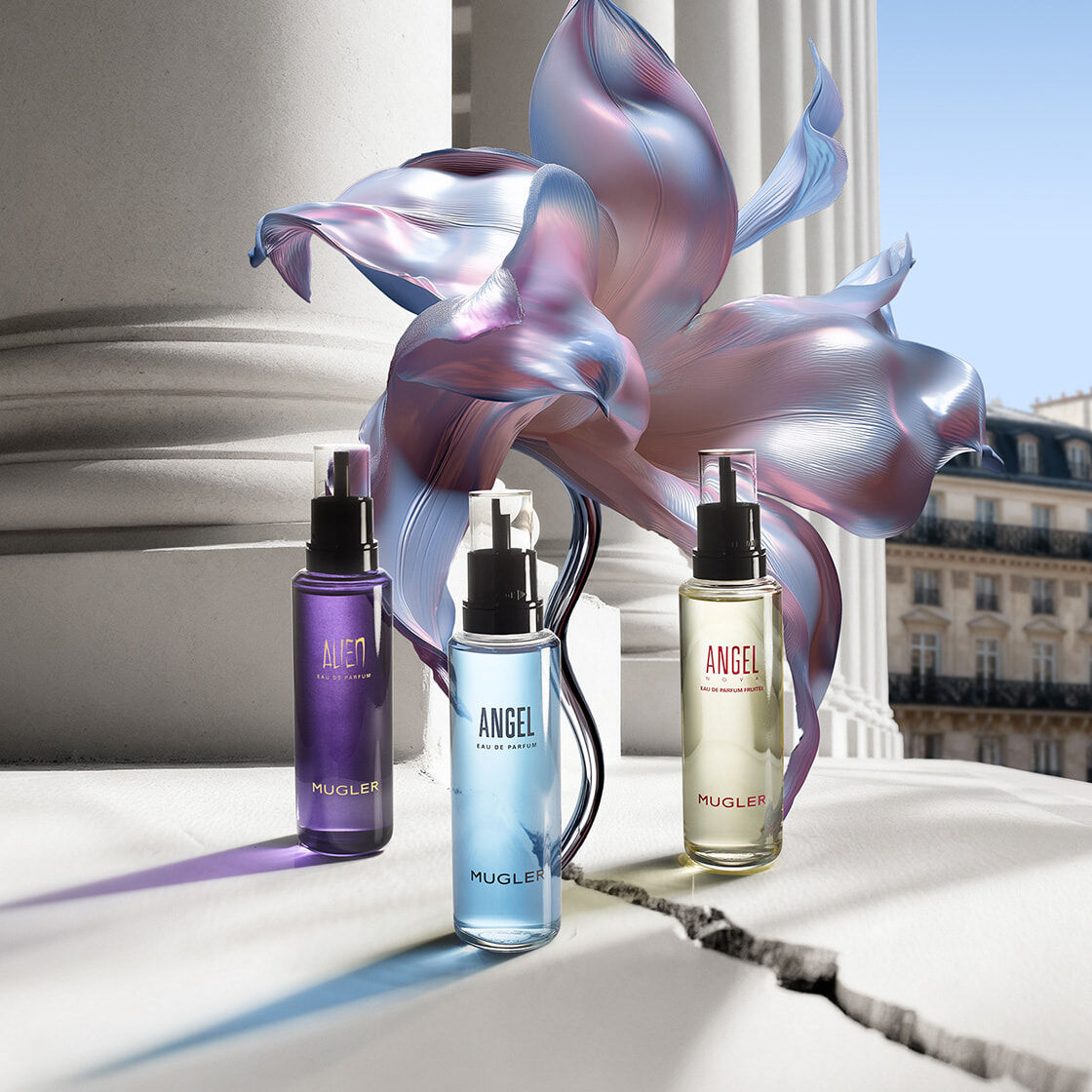 Bannière de la campagne Mugler pour la Fete des Mères 2026, mettant en scène les recharges emblématiques Angel et Alien dans un décor floral céleste et un paysage parisien, en hommage aux mères exceptionnelles.