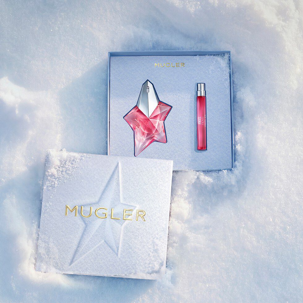 Un coffret cadeau Mugler bleu glacier, ouvert, texturé et scintillant, posé sur de la neige, dévoilant un coffret cadeau Angel Nova Eau de Parfum de 50 ml