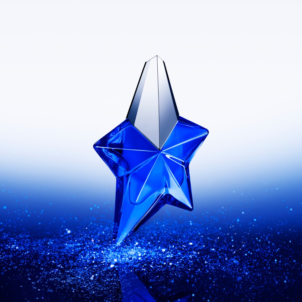 Flacon de parfum en forme d'étoile, bleu vif, scintillant sur un fond dégradé de bleu.